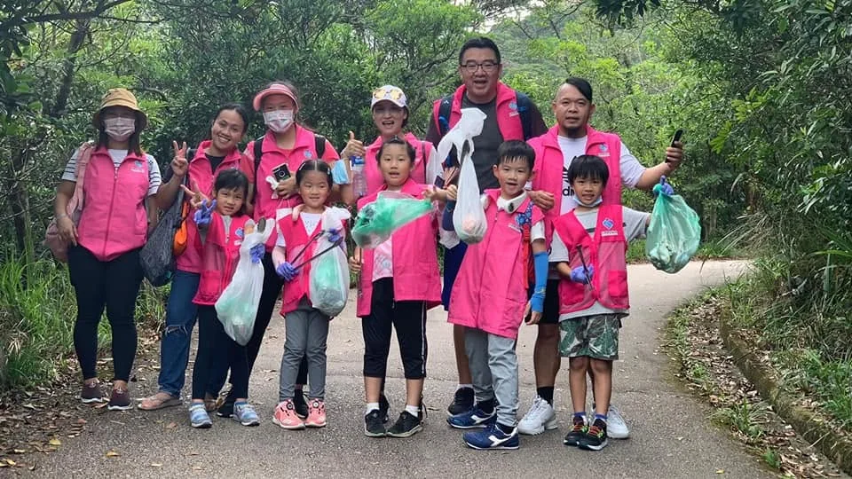 Junior and adult volunteers posing together on a trail.